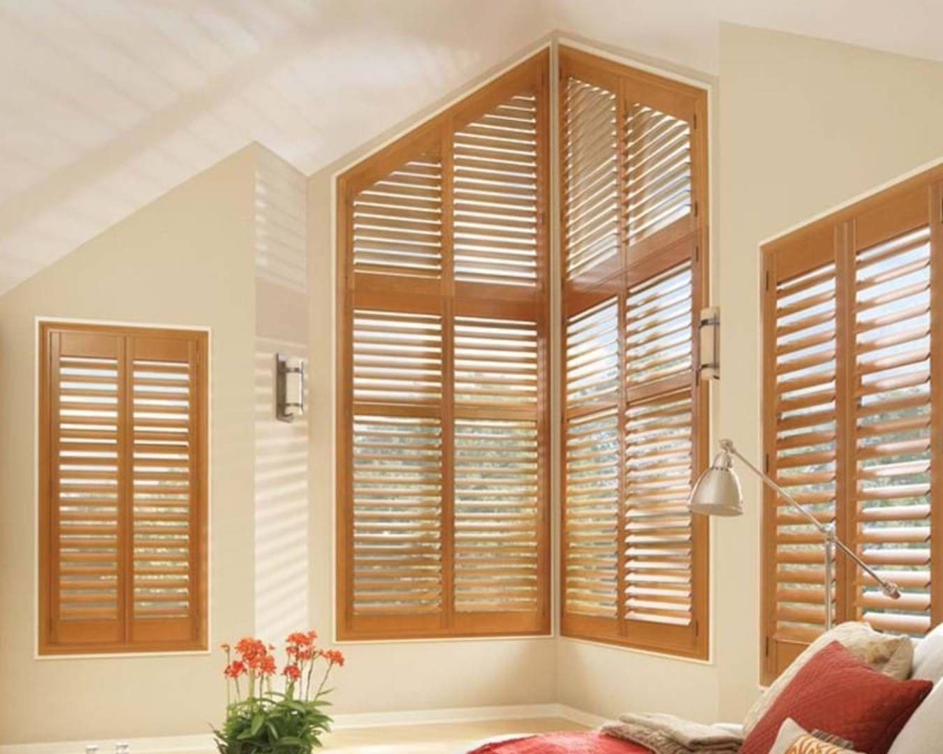 A living room with a large window and wooden shutters