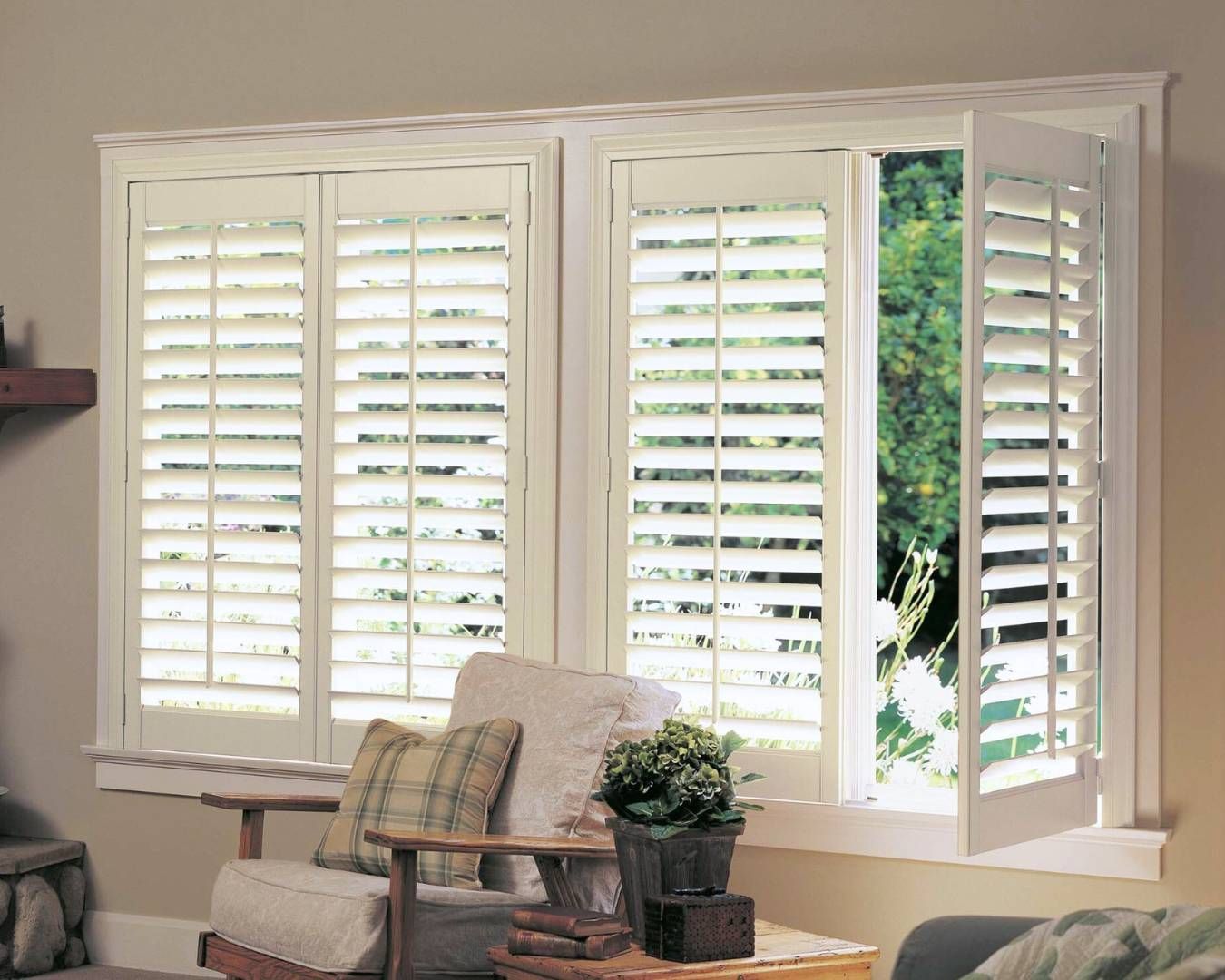 A living room with white shutters on the windows