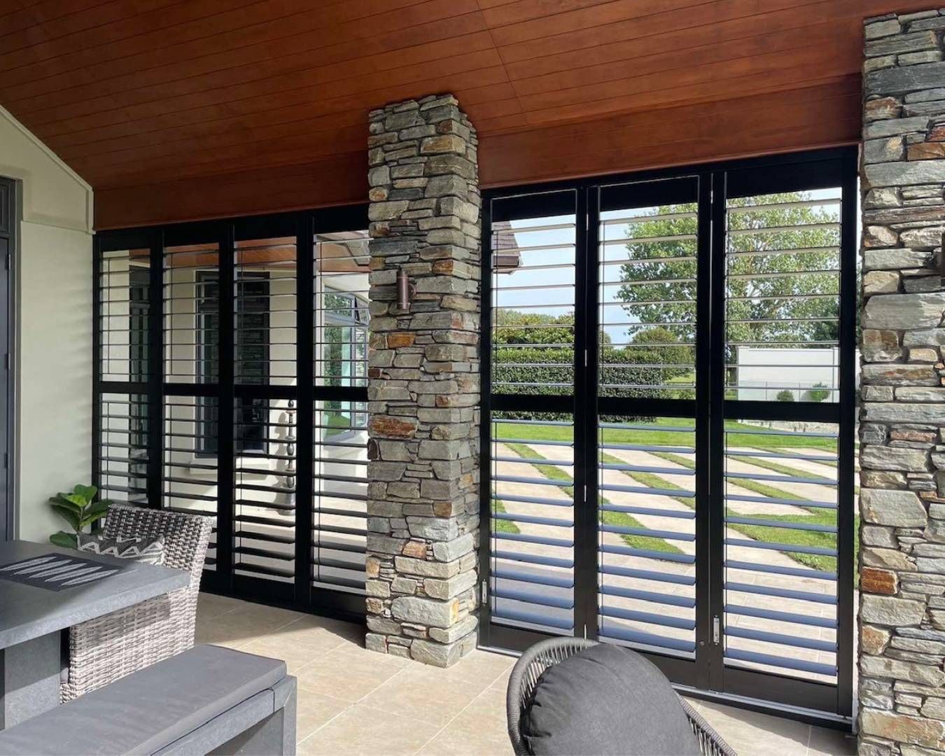 A room with a lot of windows and a stone wall