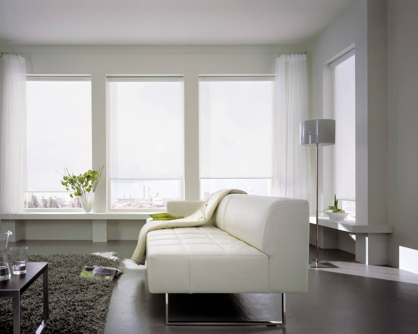 A living room with a white couch and lots of windows