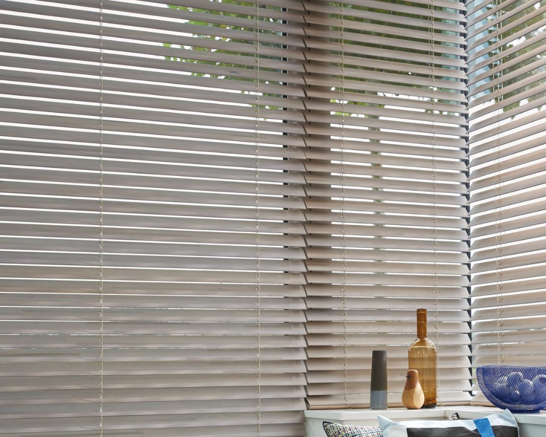 A window with blinds on it and a sink in the background