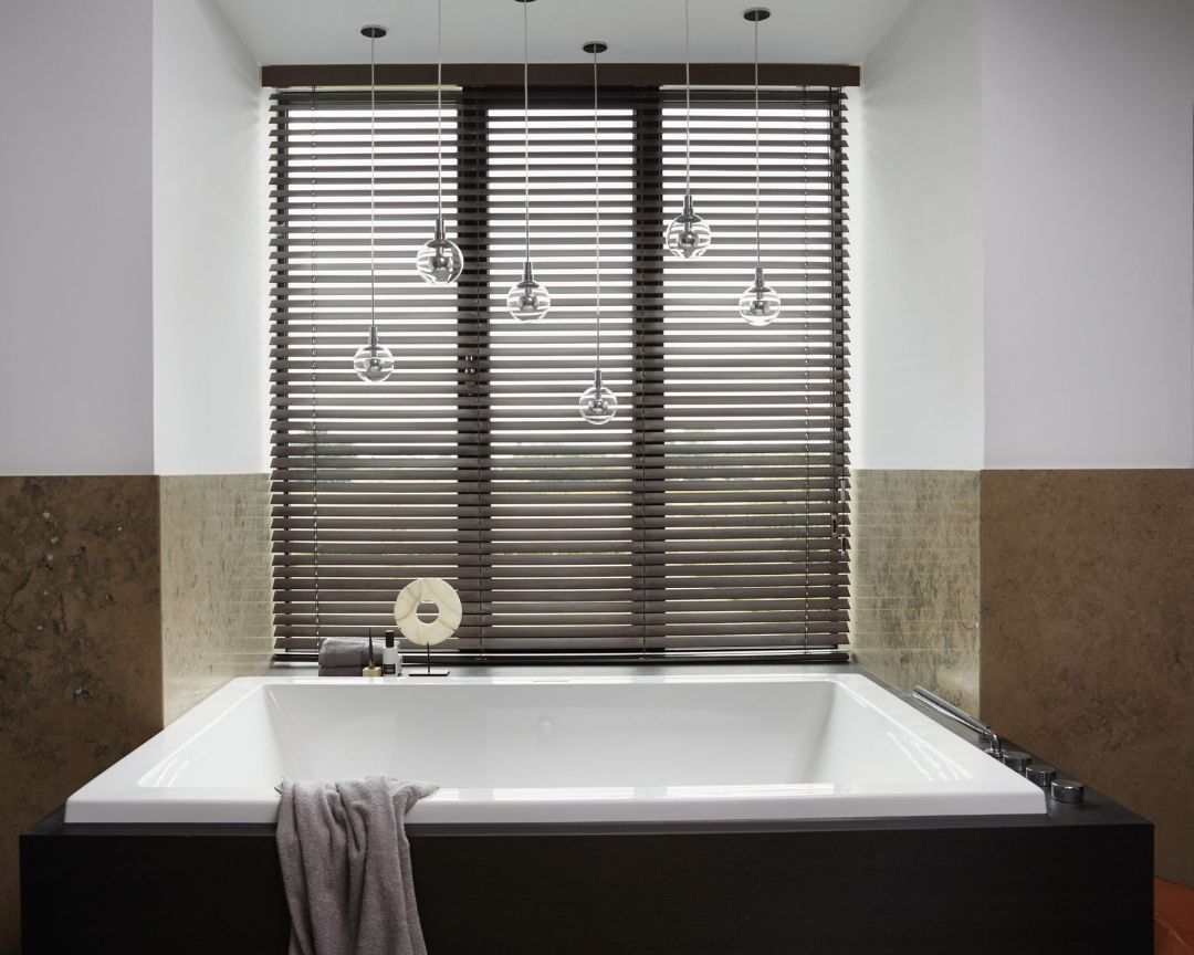A bathroom with a bathtub and a window with blinds