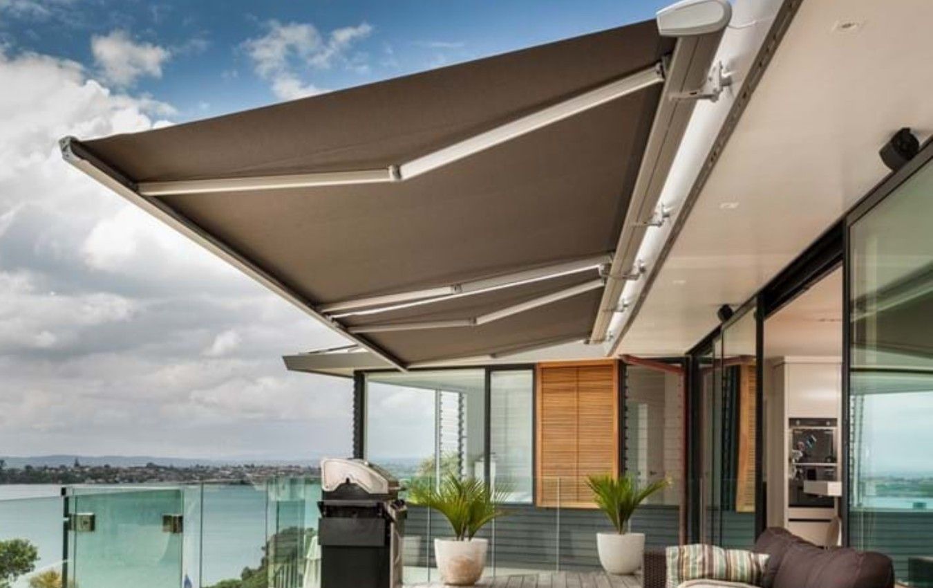 A balcony with a large awning over it and a view of the ocean.
