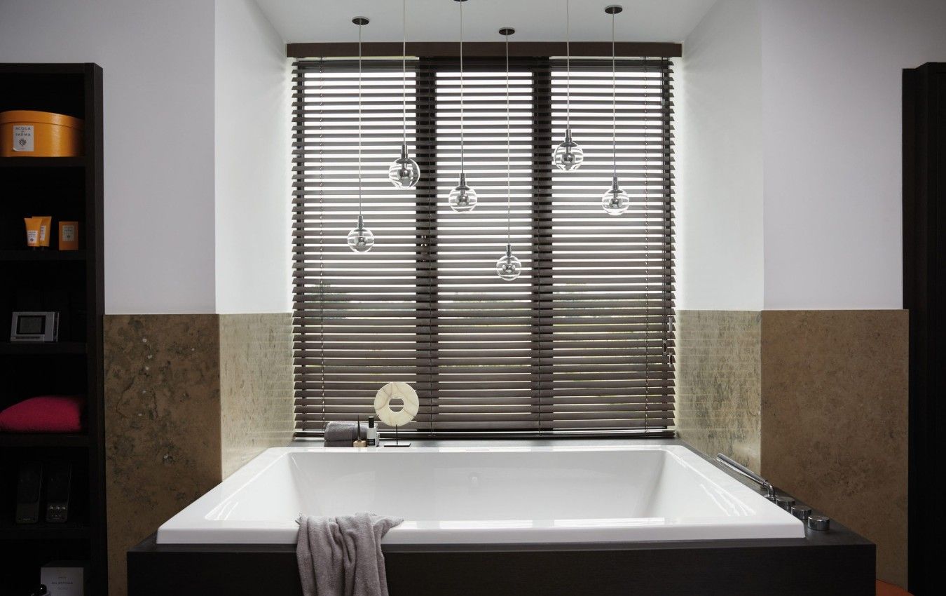 A bathroom with a bathtub and a window with blinds