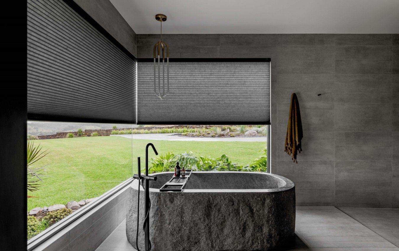 A bathroom with a large bathtub and a large window.