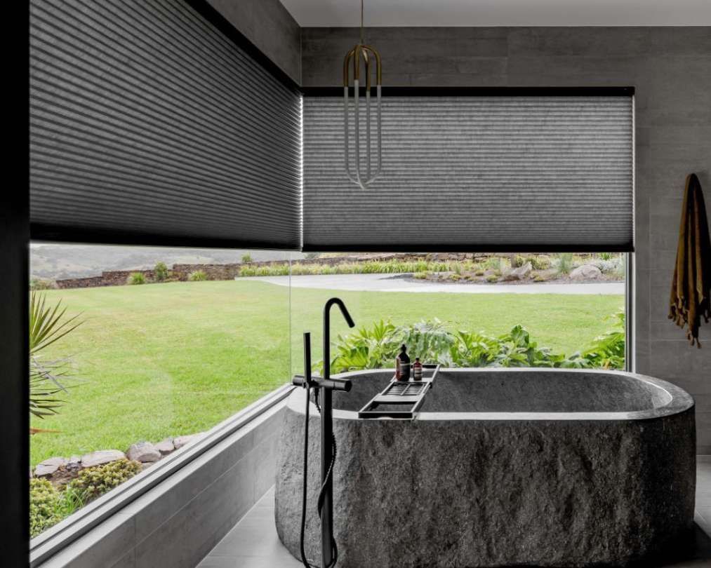 A bathroom with a large stone bathtub and a large window.