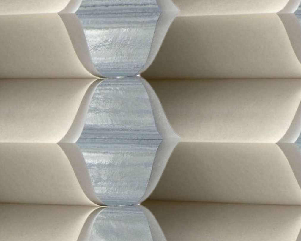 A close up of a honeycomb blind on a window.