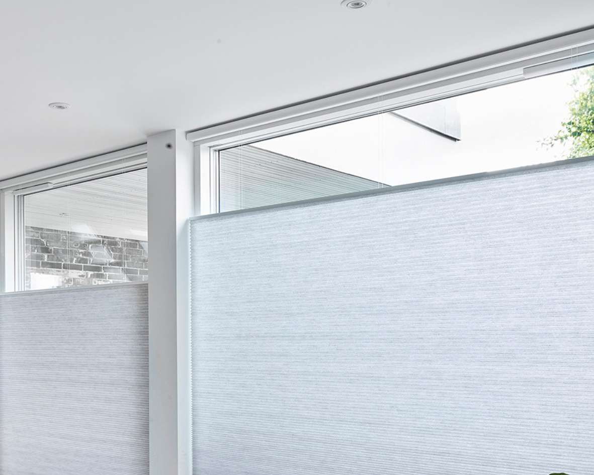 A room with a lot of windows and a white wall.