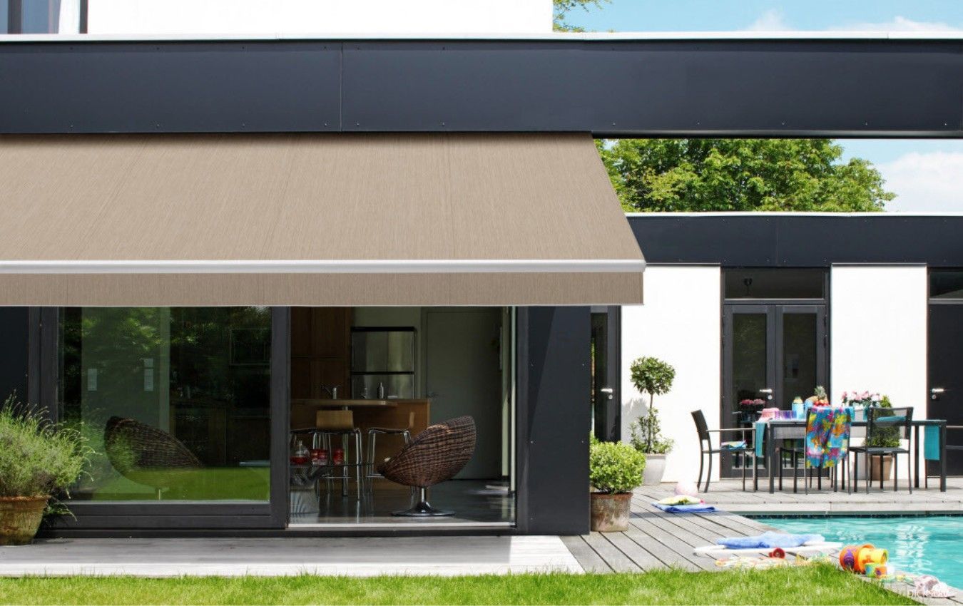 A house with a swimming pool and a table and chairs in front of it.