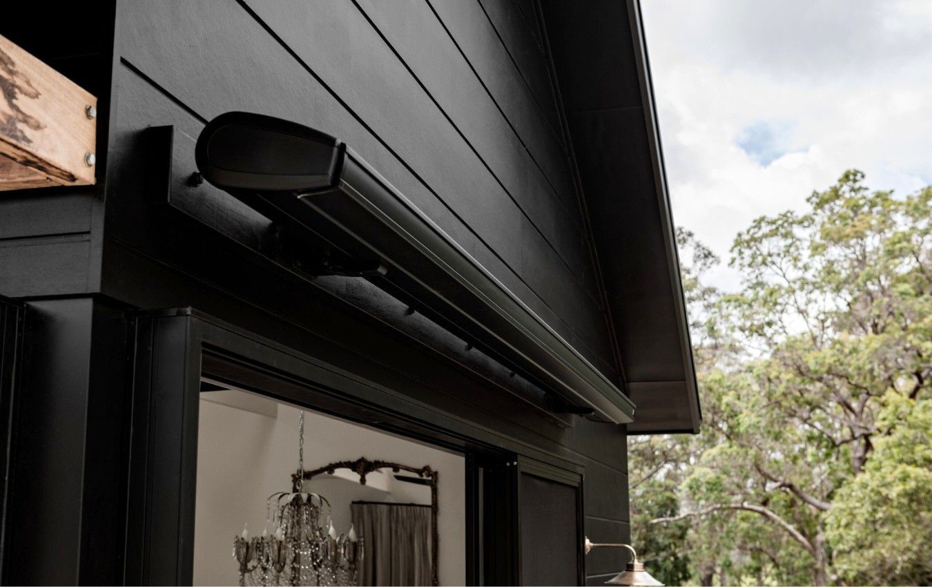 A black house with a black awning on the side of it.