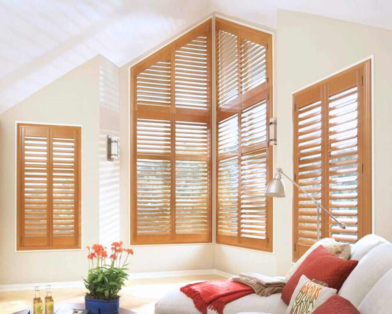 A living room with a couch and shutters on the windows