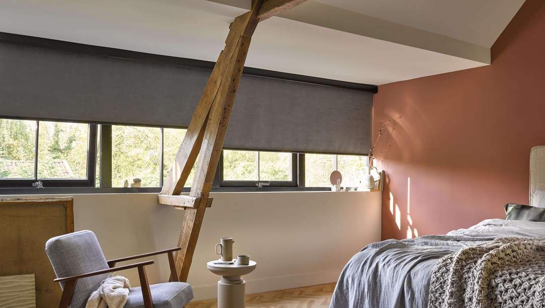 A bedroom with a bed , chair , and window.