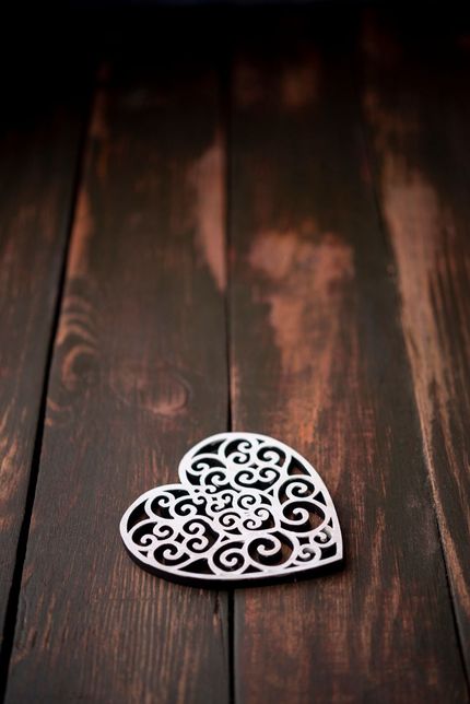 Un corazón calado, blanco y ornamentado, con un diseño de filigrana