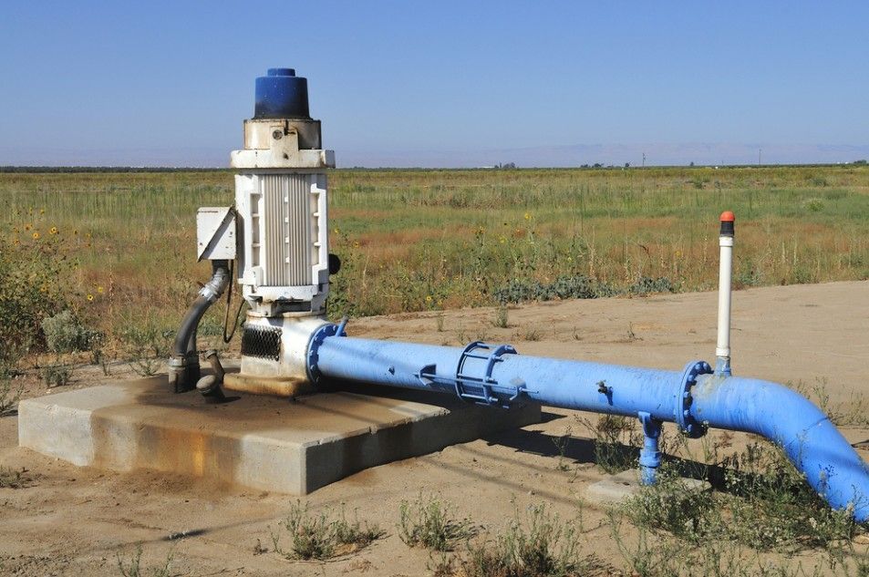 A Blue Pipe is Connected to a Pump in the Middle of a Field — Wade N Water In Walcha, NSW