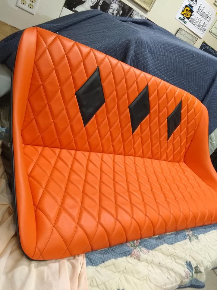 An orange couch with black diamonds on it