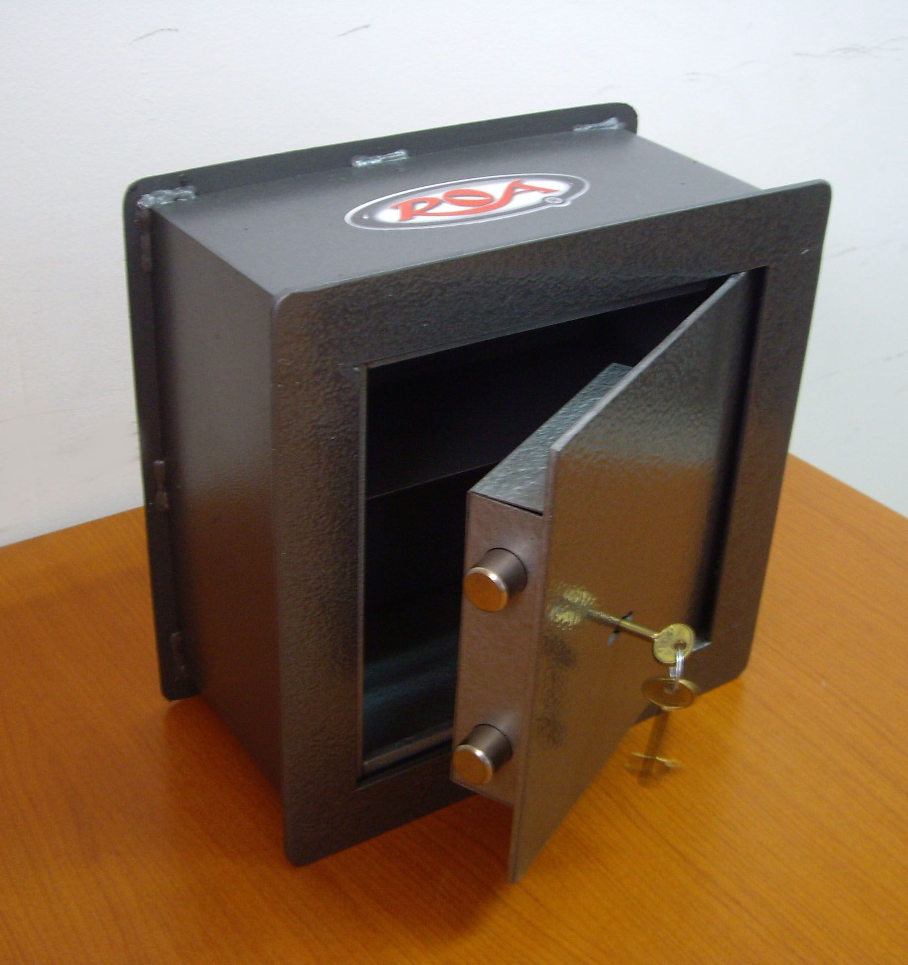 Caja fuerte de metal negro abierta con la puerta parcialmente abierta y la cerradura visible,