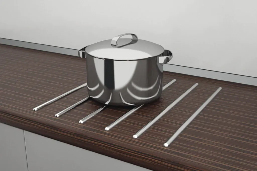 Olla de acero inoxidable sobre una rejilla oscura para encimera con soportes blancos.