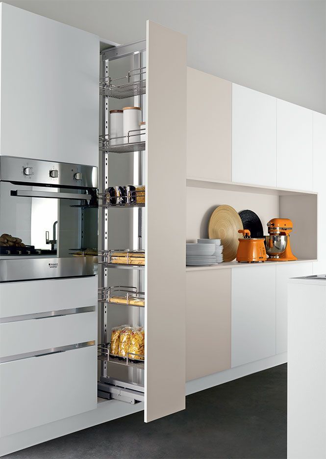 Cocina moderna con despensa extraíble llena de frascos y conservas junto al horno empotrado y los armarios.