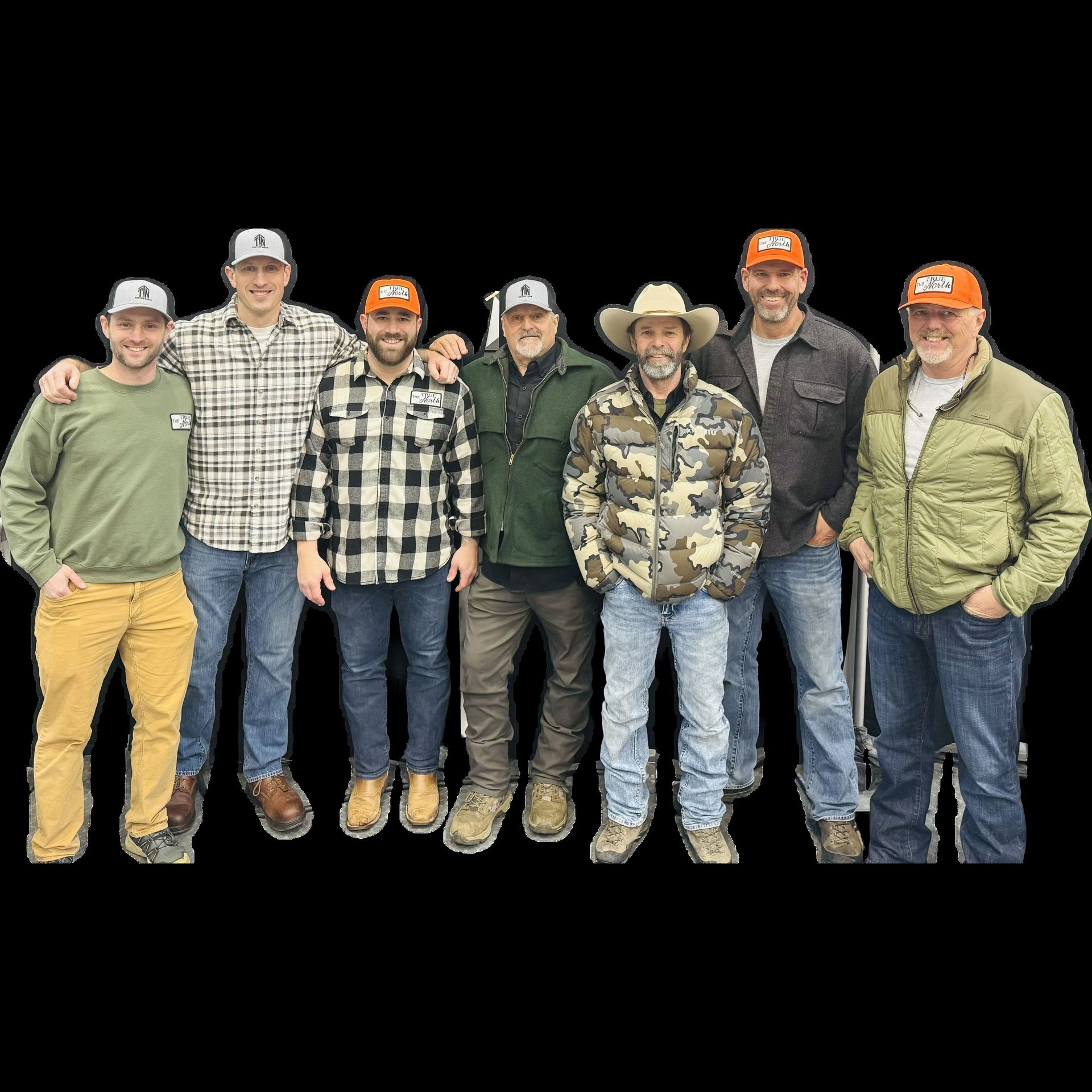 Group of men standing together; some wearing hats and jackets.