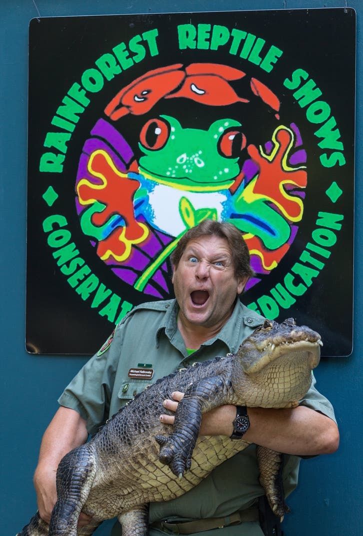 Man holding alligator in front of 