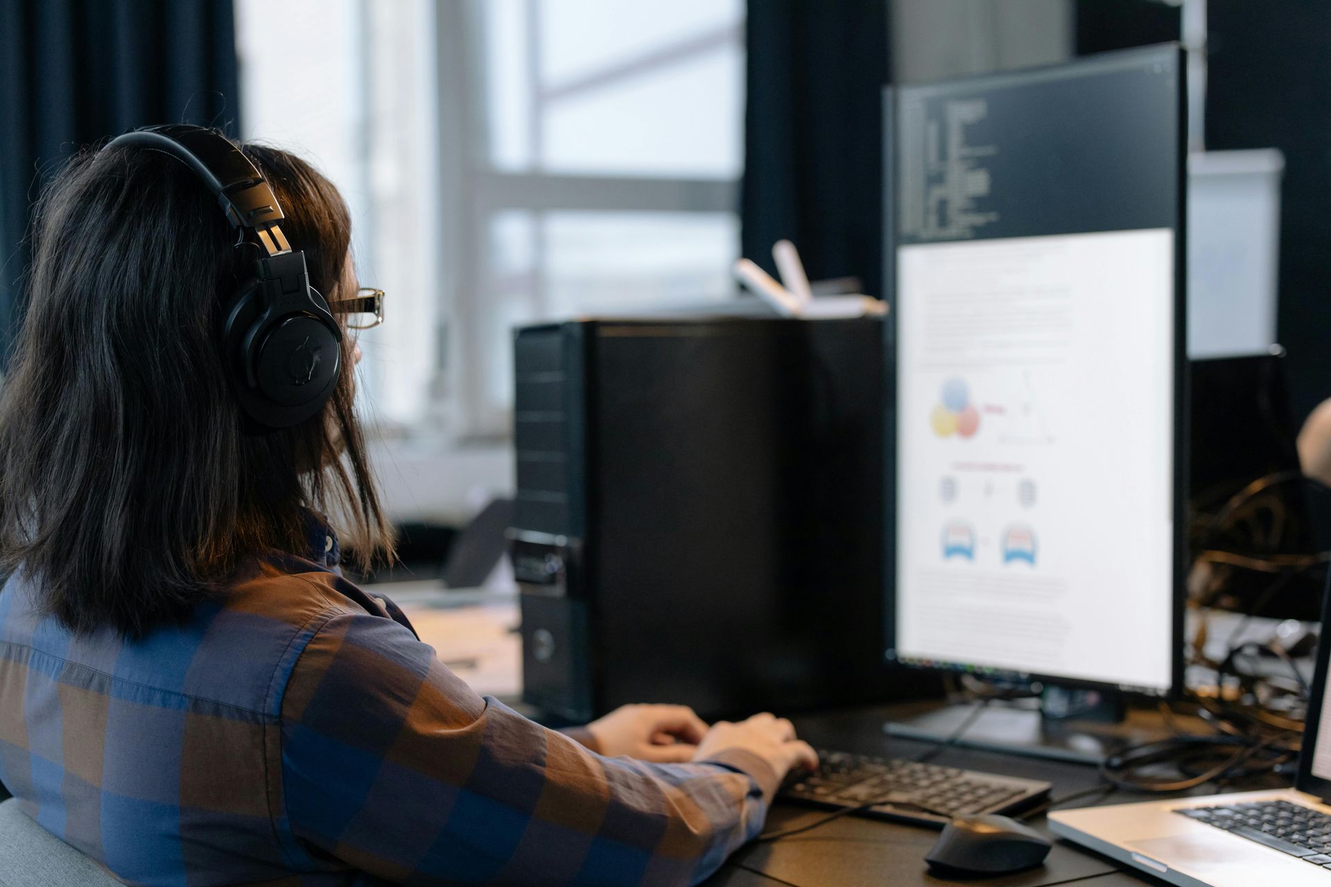 A Woman Wearing Headphones Is Sitting In Front Of A Computer — D-stress Computers In Idalia, QLD
