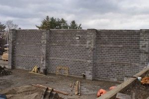Unfinished gray cinder block wall at a construction site under an overcast sky