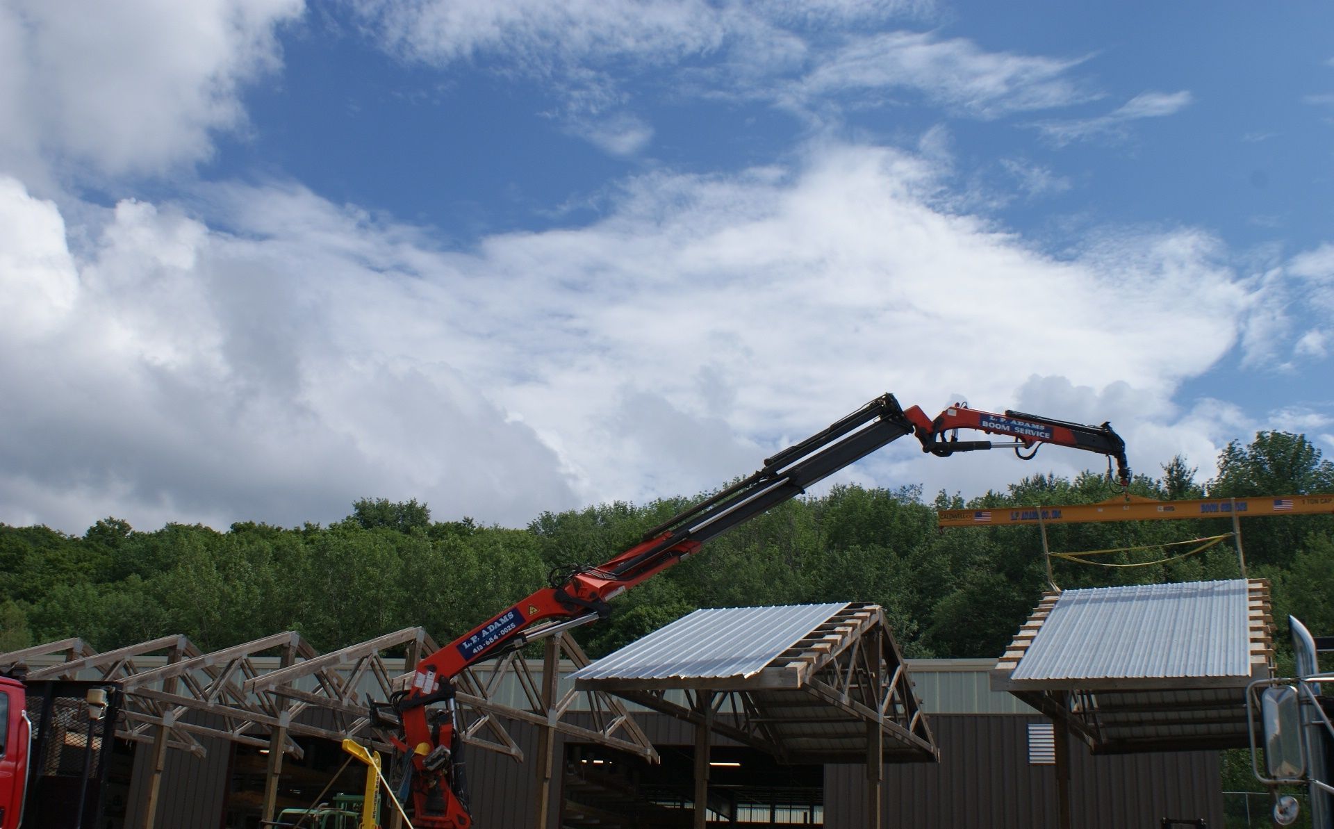 Fire truck ladder extended over damaged buildings under cloudy sky