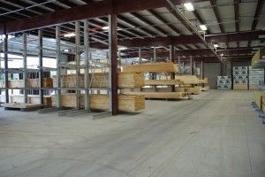 Empty warehouse interior with stacked pallets and shelves under exposed steel beams