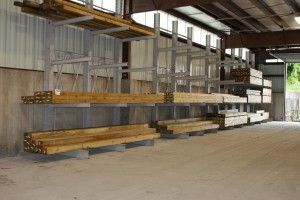 Warehouse interior with long stacked metal beams on shelving racks
