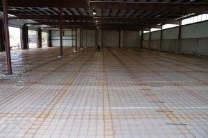 Empty industrial warehouse interior with concrete floor and metal roof beams