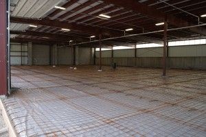 Empty industrial warehouse interior with metal beams and a concrete floor
