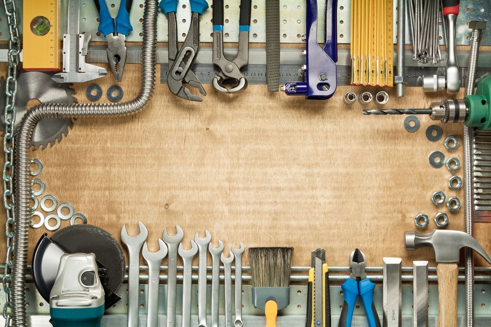 Tool-filled workbench with wrenches, pliers, and drills around a blank wooden center panel