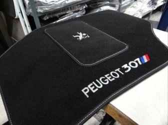 El interior de un coche con suelo alfombrado y pedal de freno.