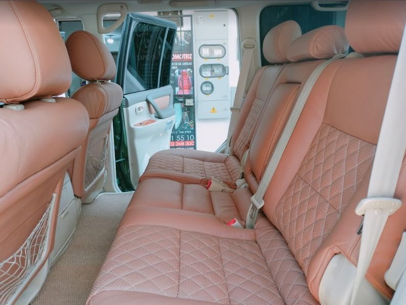 El asiento trasero de un coche con asientos de cuero marrón.