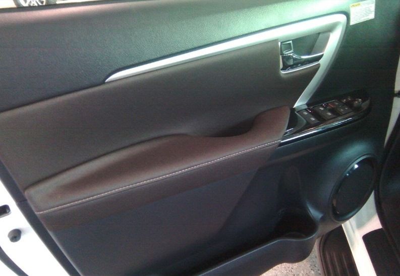 El interior de un coche blanco con un panel de puerta negro.