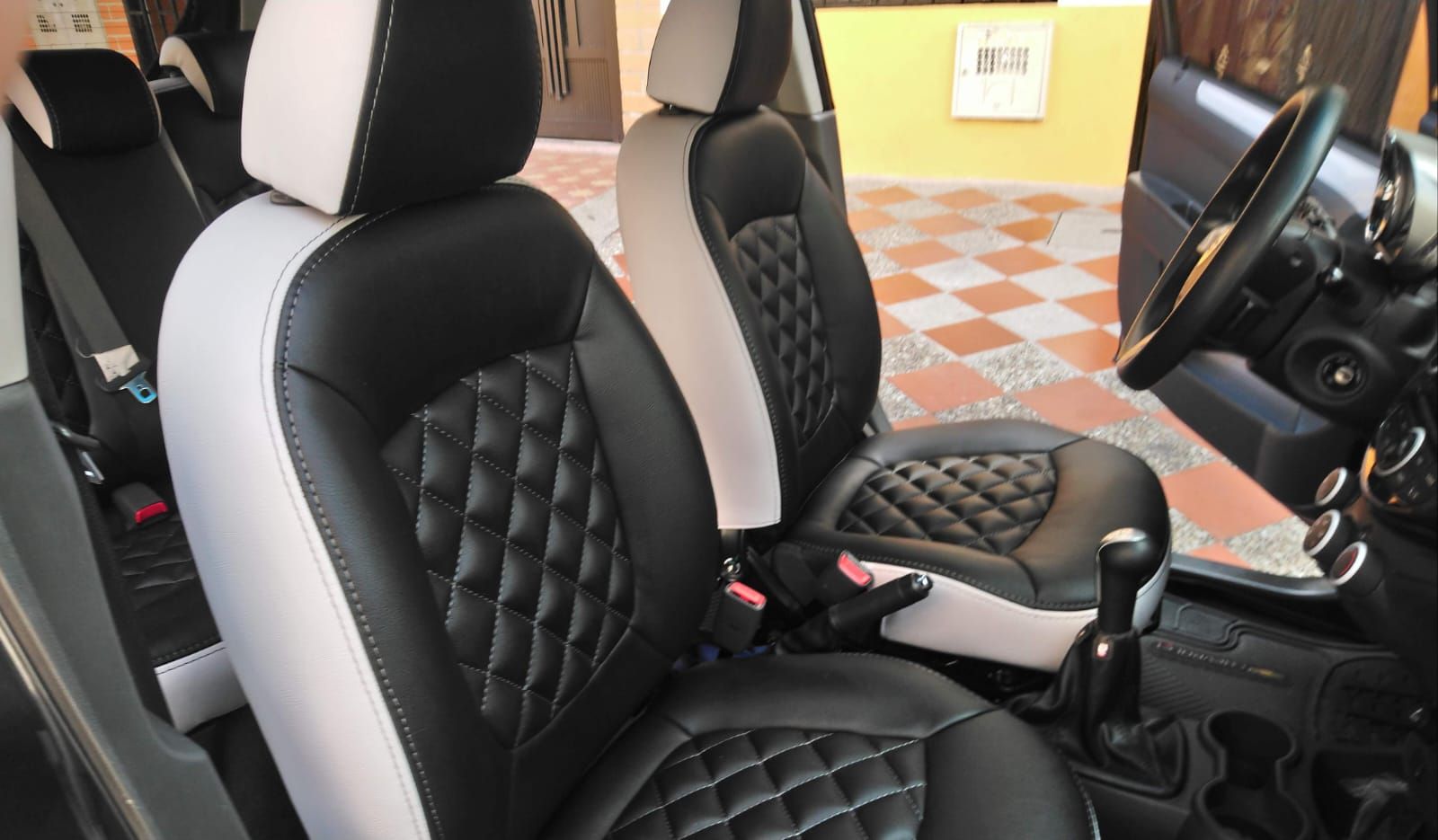 Un coche con fundas de asientos y volante en blanco y negro.