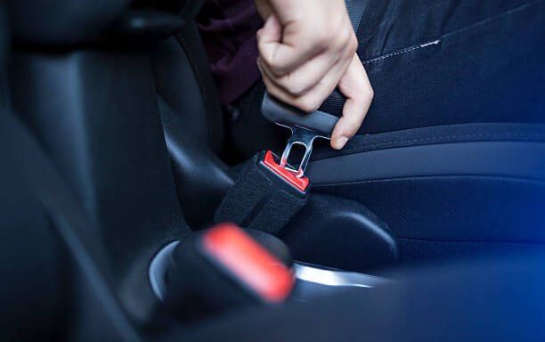 Una persona se pone el cinturón de seguridad en un coche.