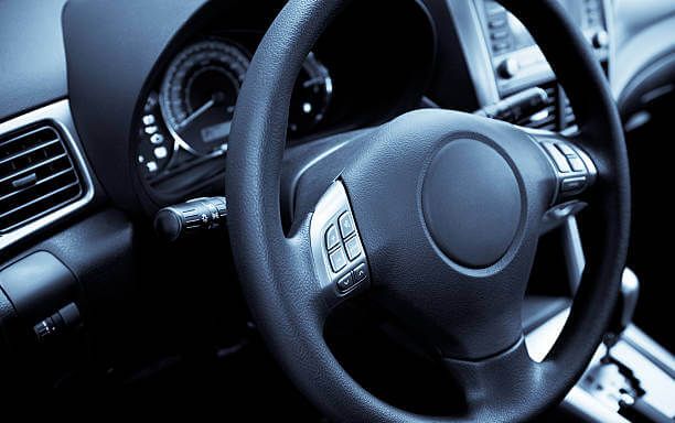 Un primer plano del volante y el tablero de un automóvil.