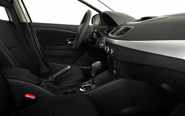El interior de un coche con un volante y un salpicadero.