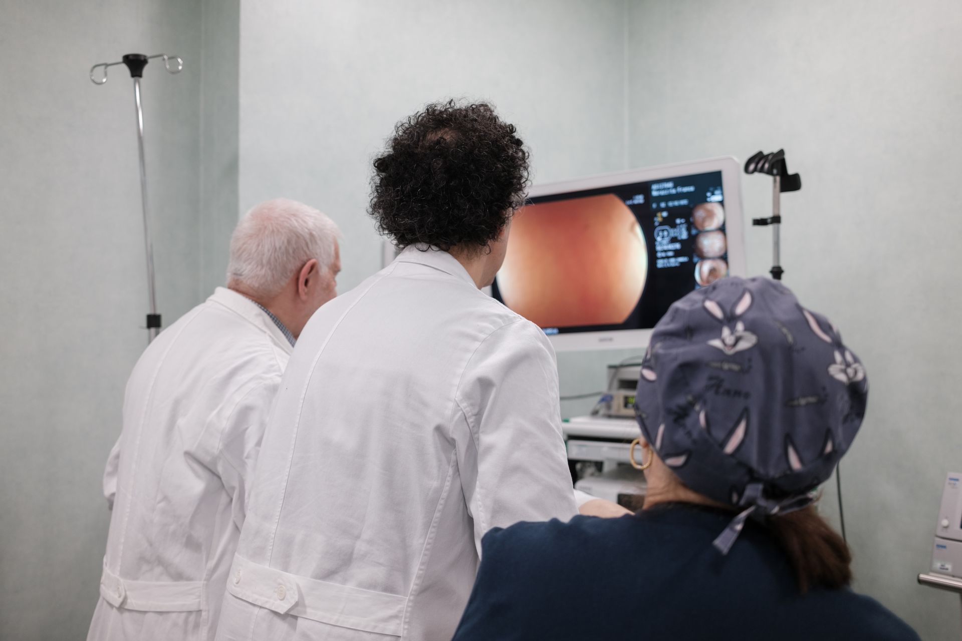 Un gruppo di medici guarda un monitor in una sala operatoria.