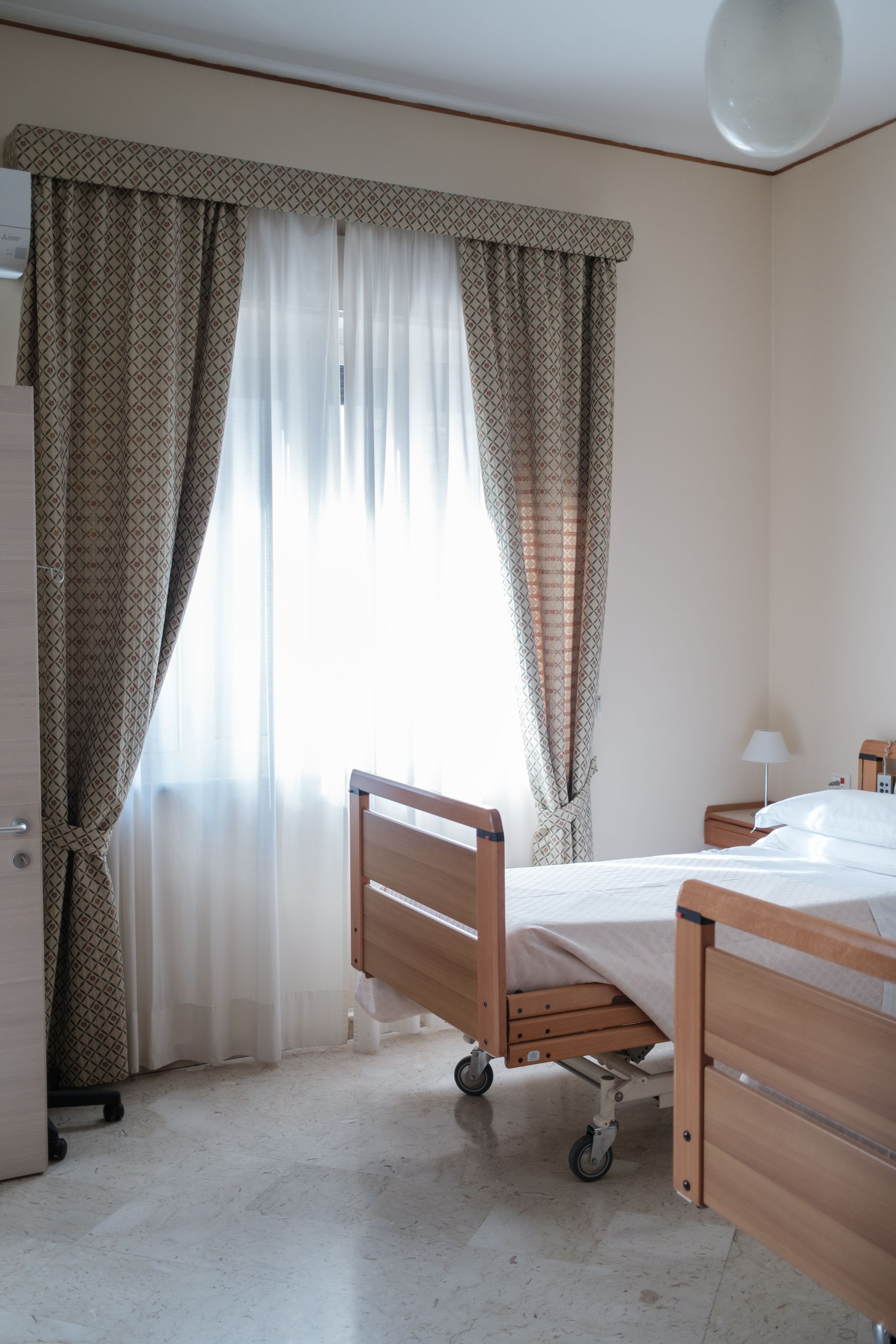 Una stanza d'ospedale con un letto e una finestra