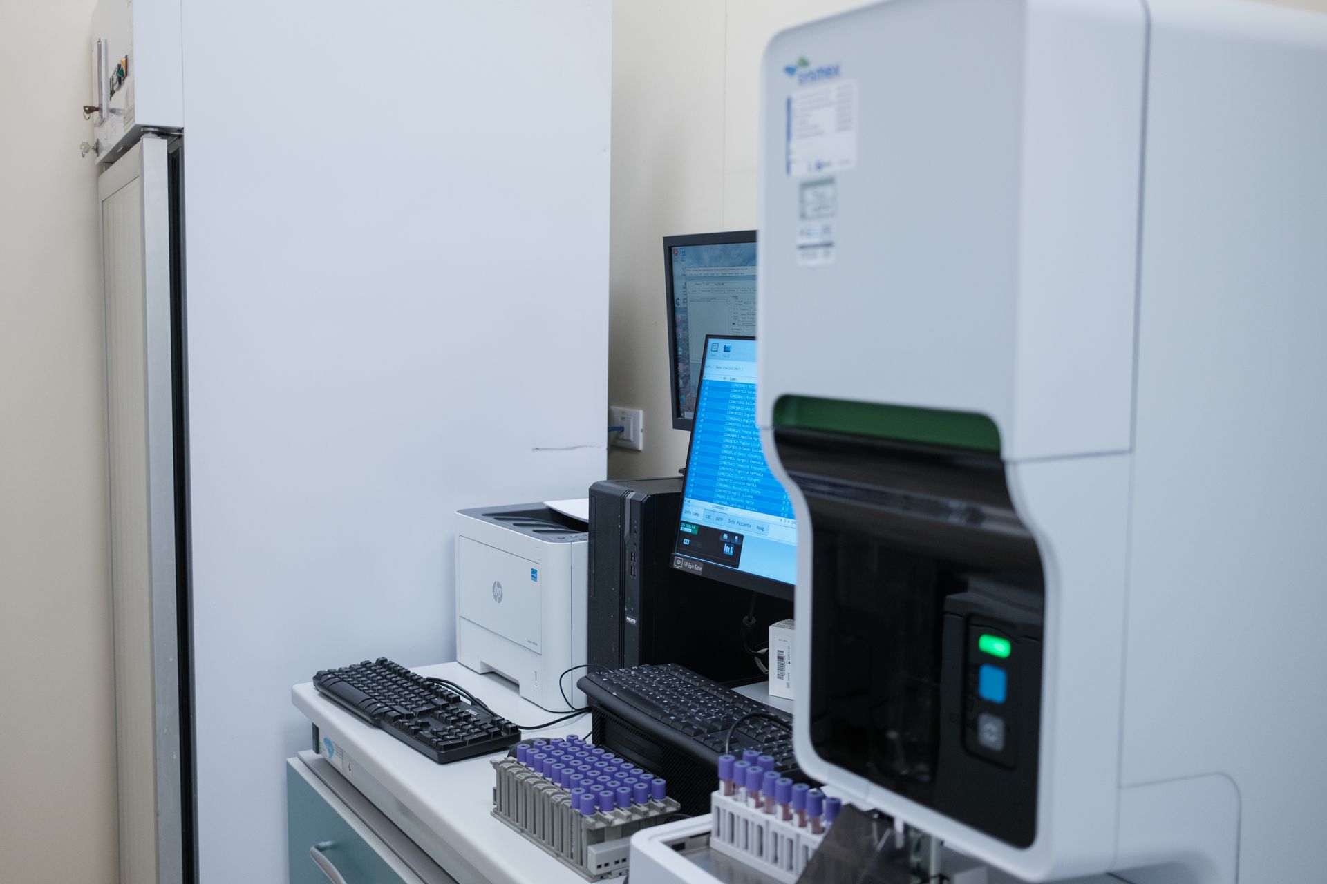 Un computer è posizionato su una scrivania accanto a una macchina in un laboratorio.