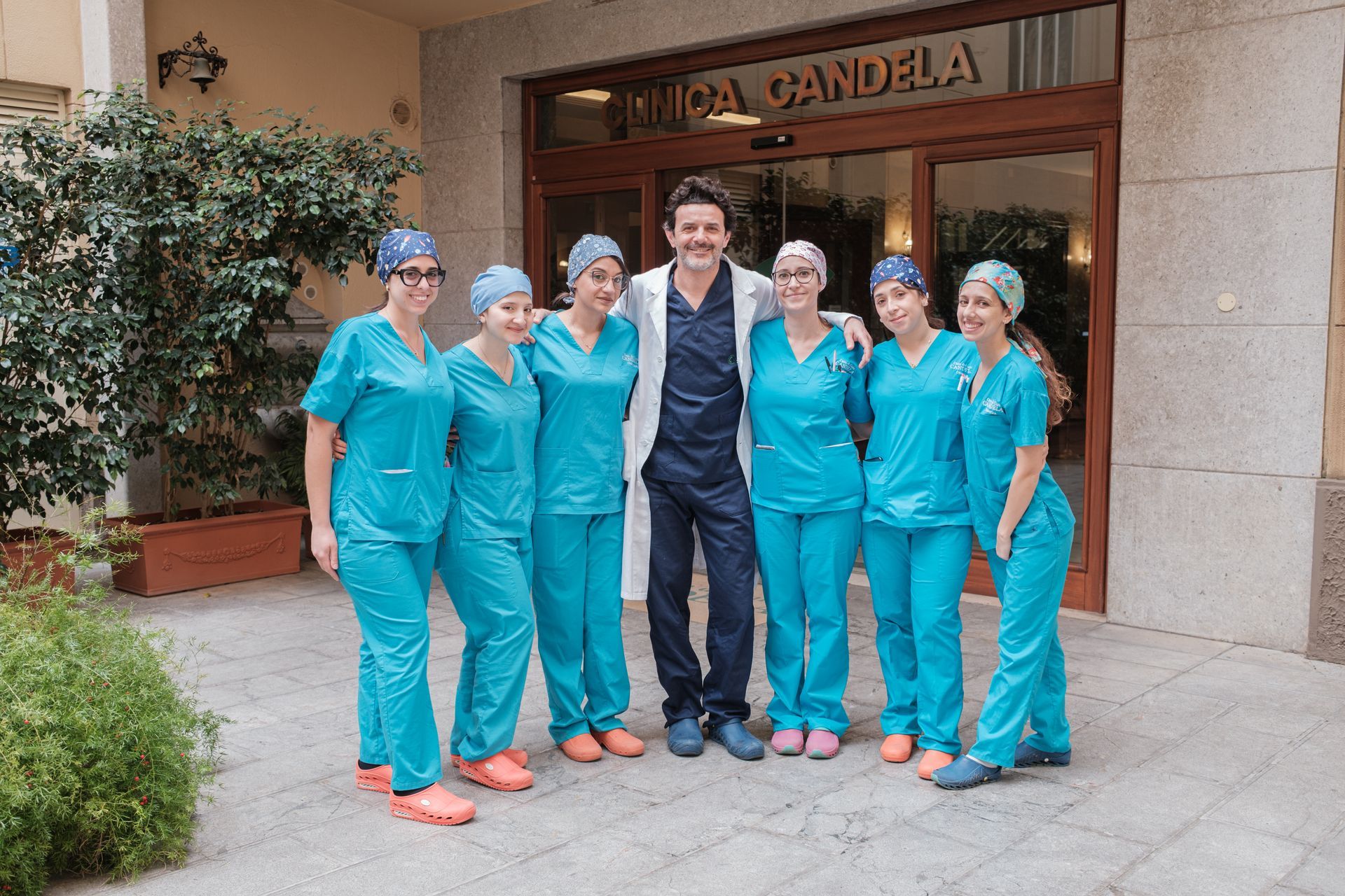 Un gruppo di infermieri posa per una foto davanti a un edificio su cui è scritto clinica candela