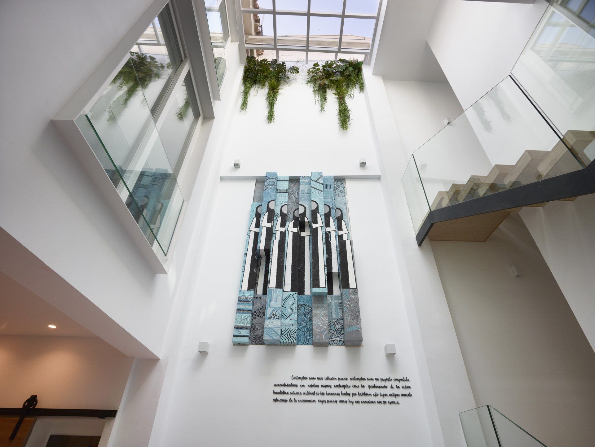 Vista aérea del lobby del hotel LD Convento Cister Málaga, con diseño moderno, alfombra geométrica y plantas decorativas.