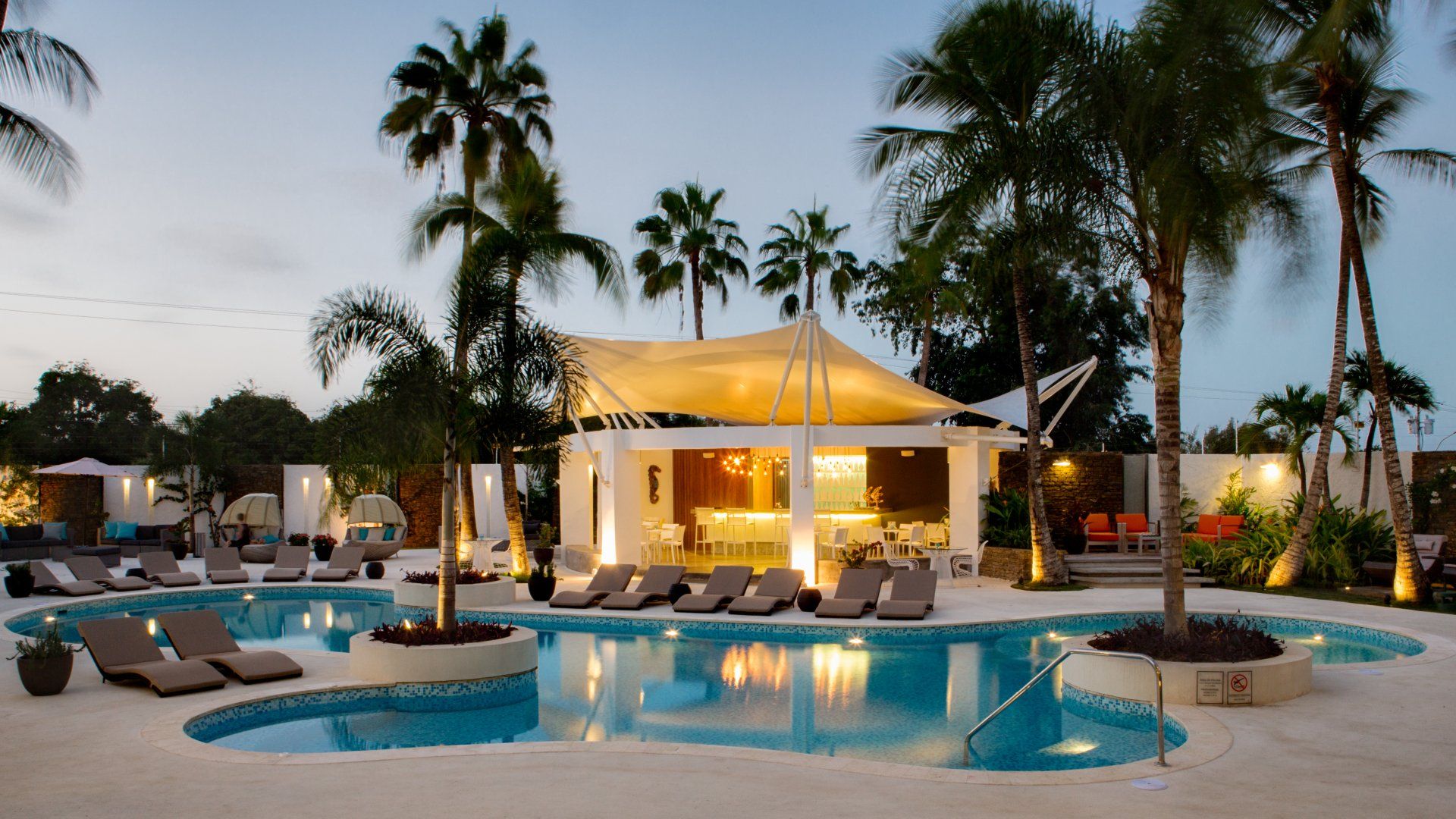 Bar y piscina del H2Otel By LD al atardecer, con ambiente tropical en Isla Margarita.