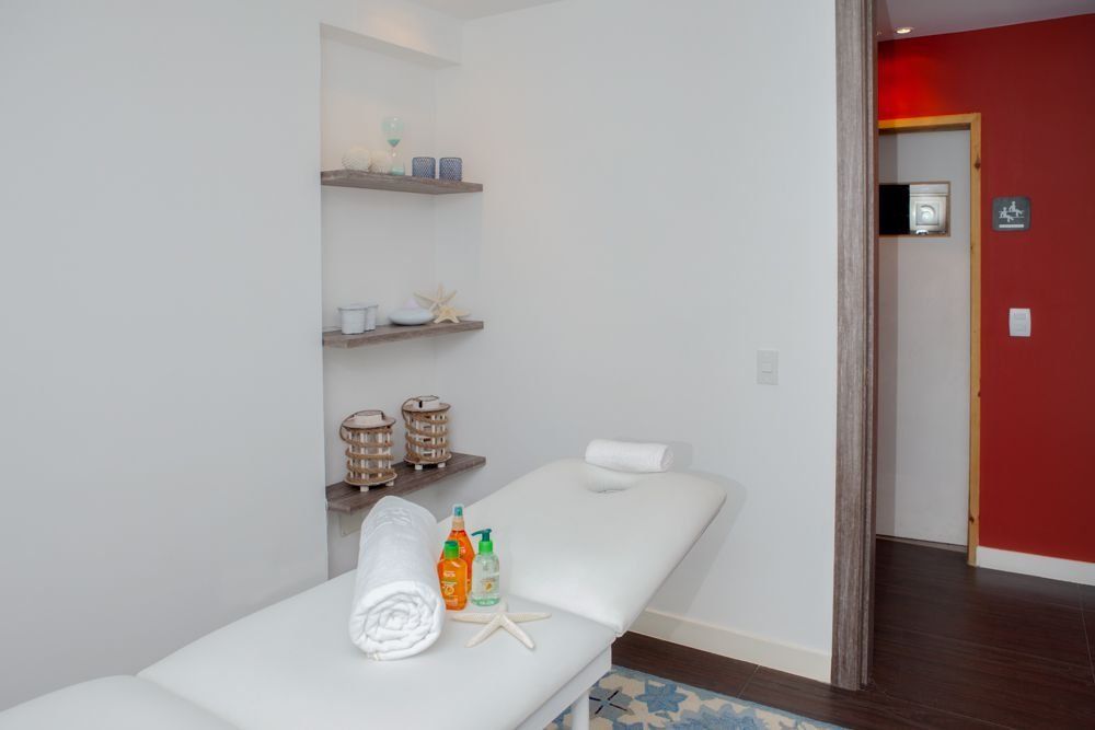 Sala de masajes serena en H2Otel by LD, con mesa blanca y detalles de relajación para un ambiente tranquilo.