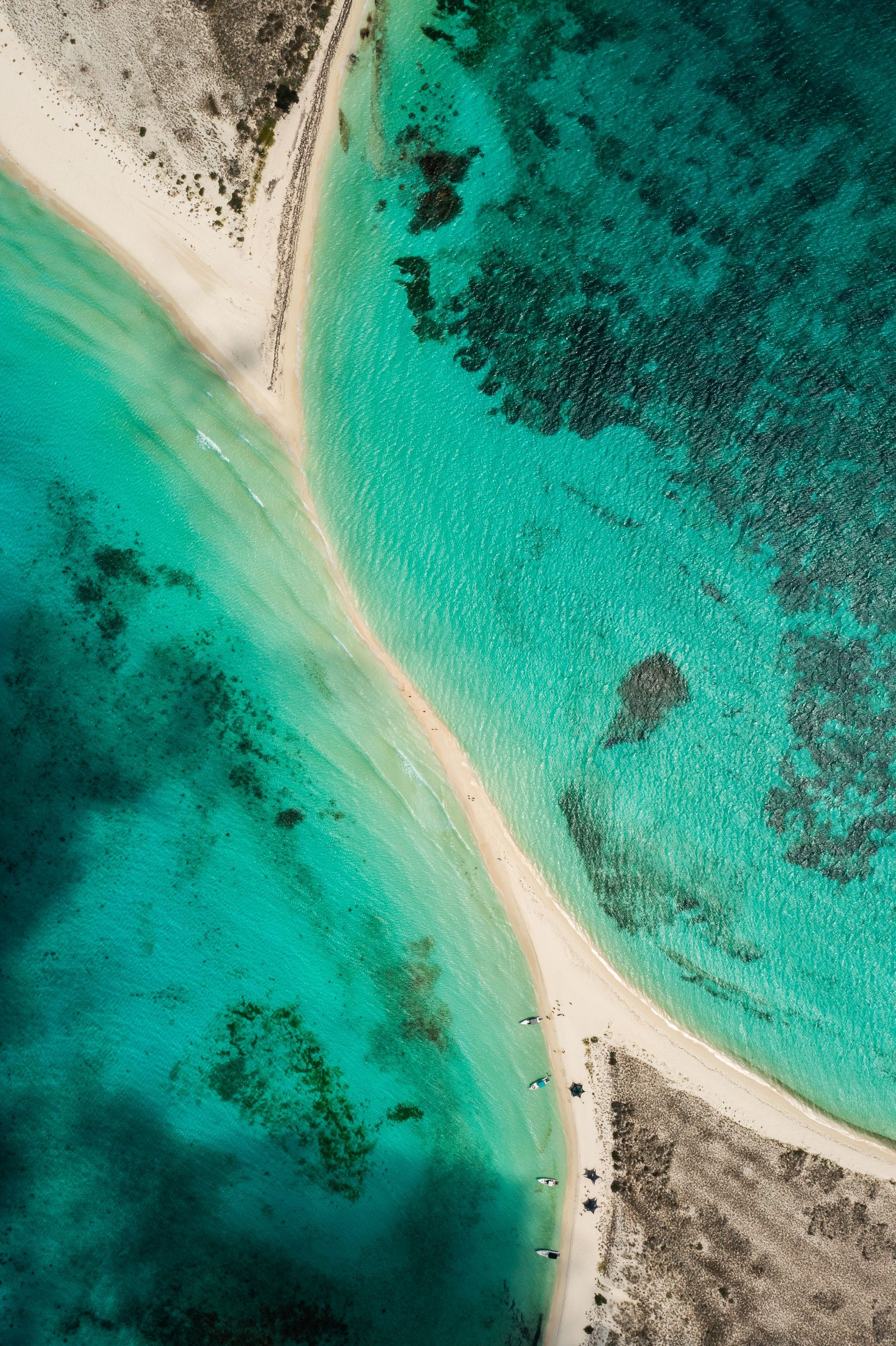Vista aérea de Cayo de Agua, con un banco de arena rodeado de aguas azules y cristalinas, ideal para el turismo.