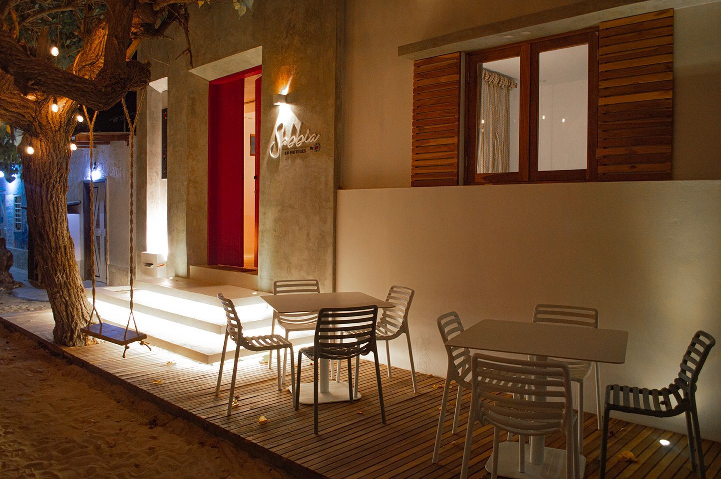 Fachada iluminada de Sabbia by LD, ambiente íntimo para encuentros nocturnos en Los Roques.