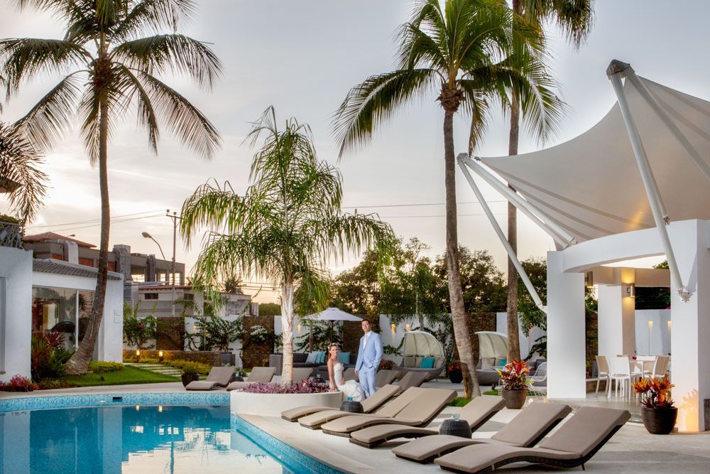 Recién casados celebrando en H2Otel by LD, con piscina y espacio para eventos al atardecer.