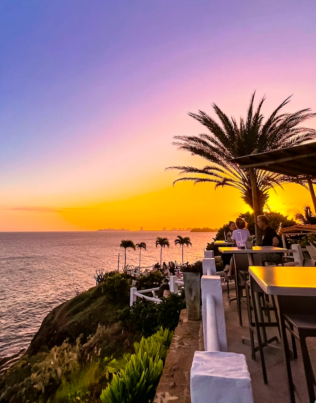 Amigas disfrutando de una comida en Restaurante Guayoyo, La Caranta de Pampatar, con vistas al mar y ambiente tropical.